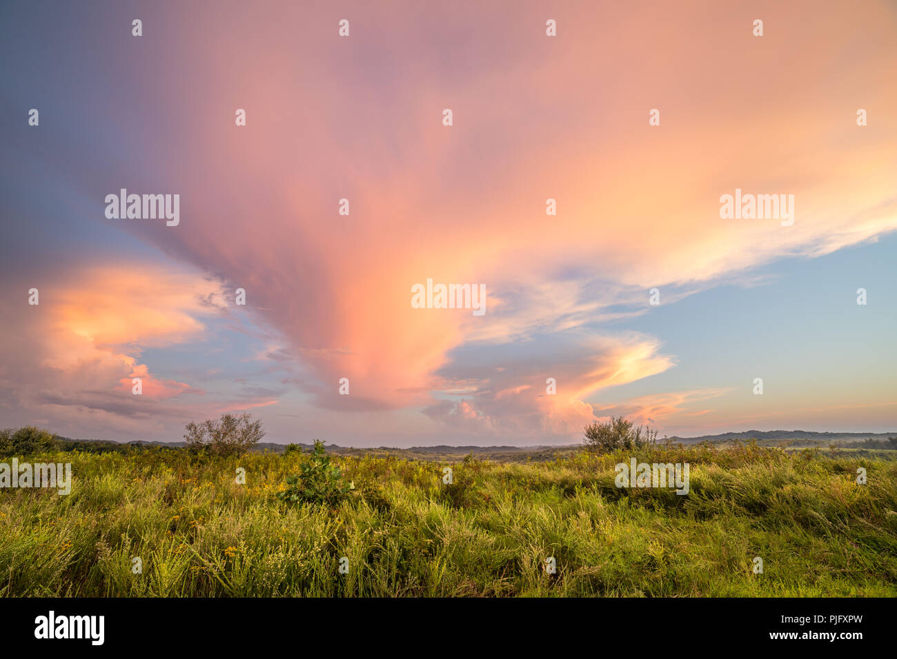 La luce del sole catture sulle nuvole in questa scena rurale. Foto Stock