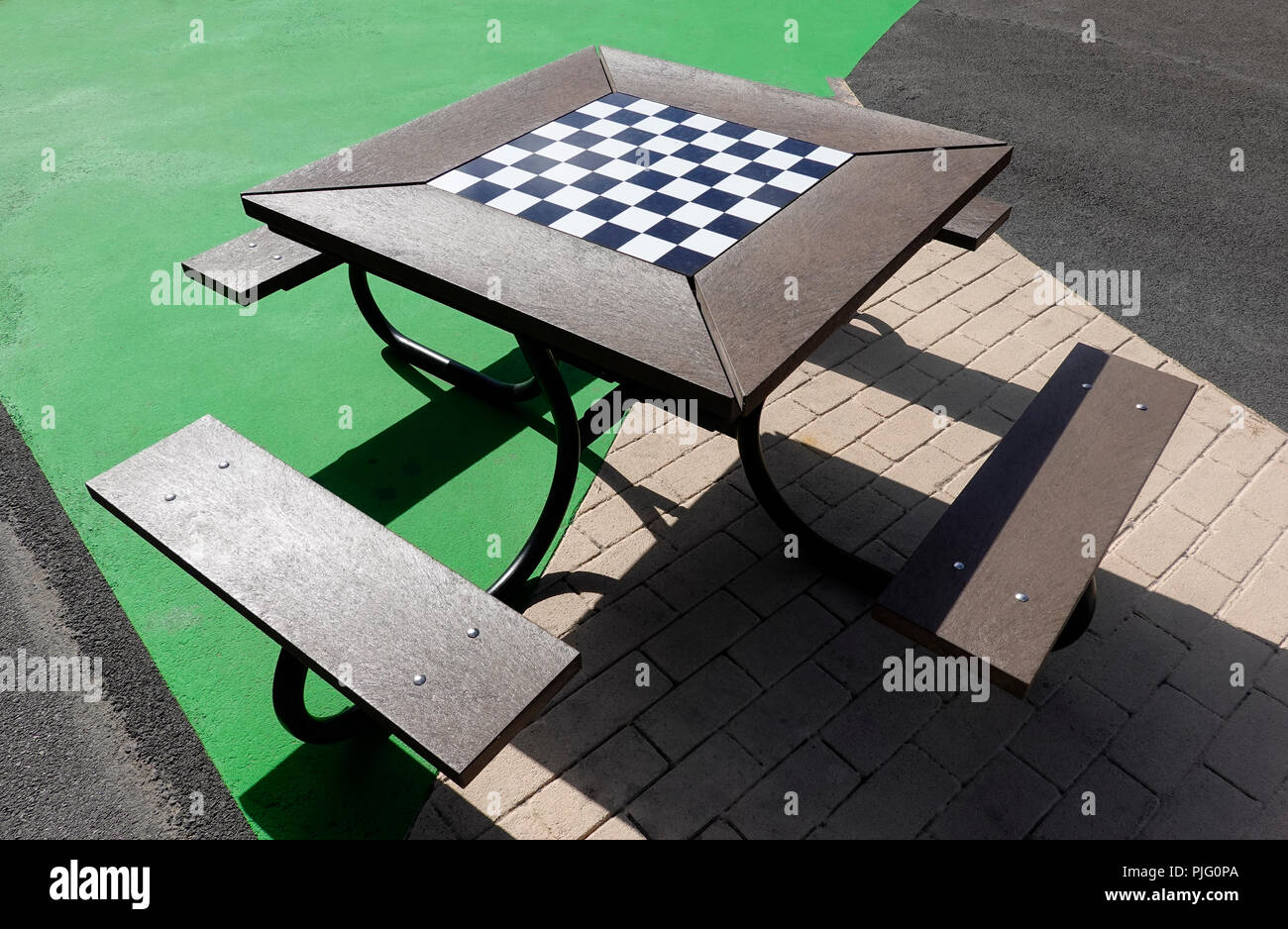 A scacchi o a dama all'esterno della scheda di gioco con panchine Foto Stock