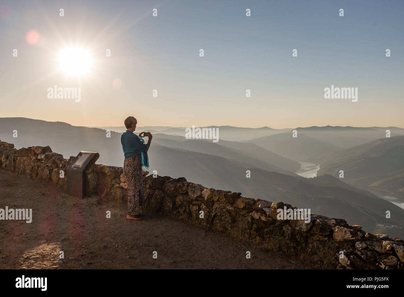 Donna di scattare una foto di una nebbiosa Valle del Douro dal viewpoint a São Leonardo de Galafura, Portogallo Foto Stock