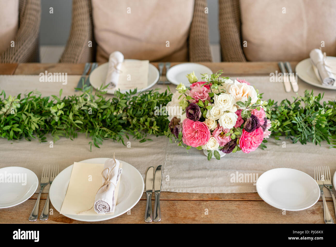 Ordinatamente intrecciati in un tubo sala da pranzo igienico decorate con un rametto di pistacchio. Banchetti per matrimoni o cene di gala. Il tavolo e sedie per gli ospiti, Servita con posateria e stoviglie. party sulla terrazza Foto Stock