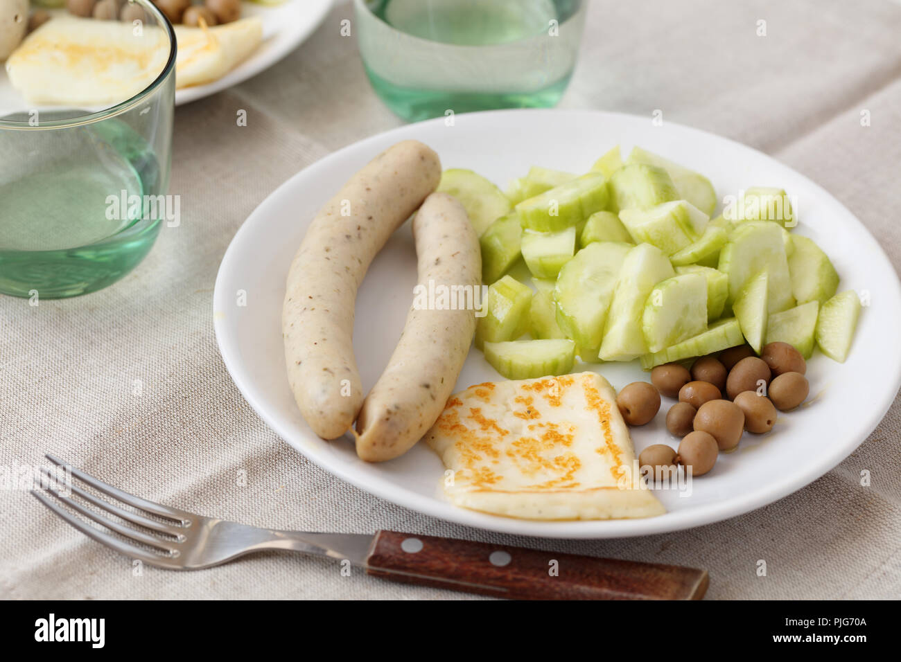 Salsicce bianche con arrosti di carne il formaggio halloumi, cetrioli e olive Foto Stock