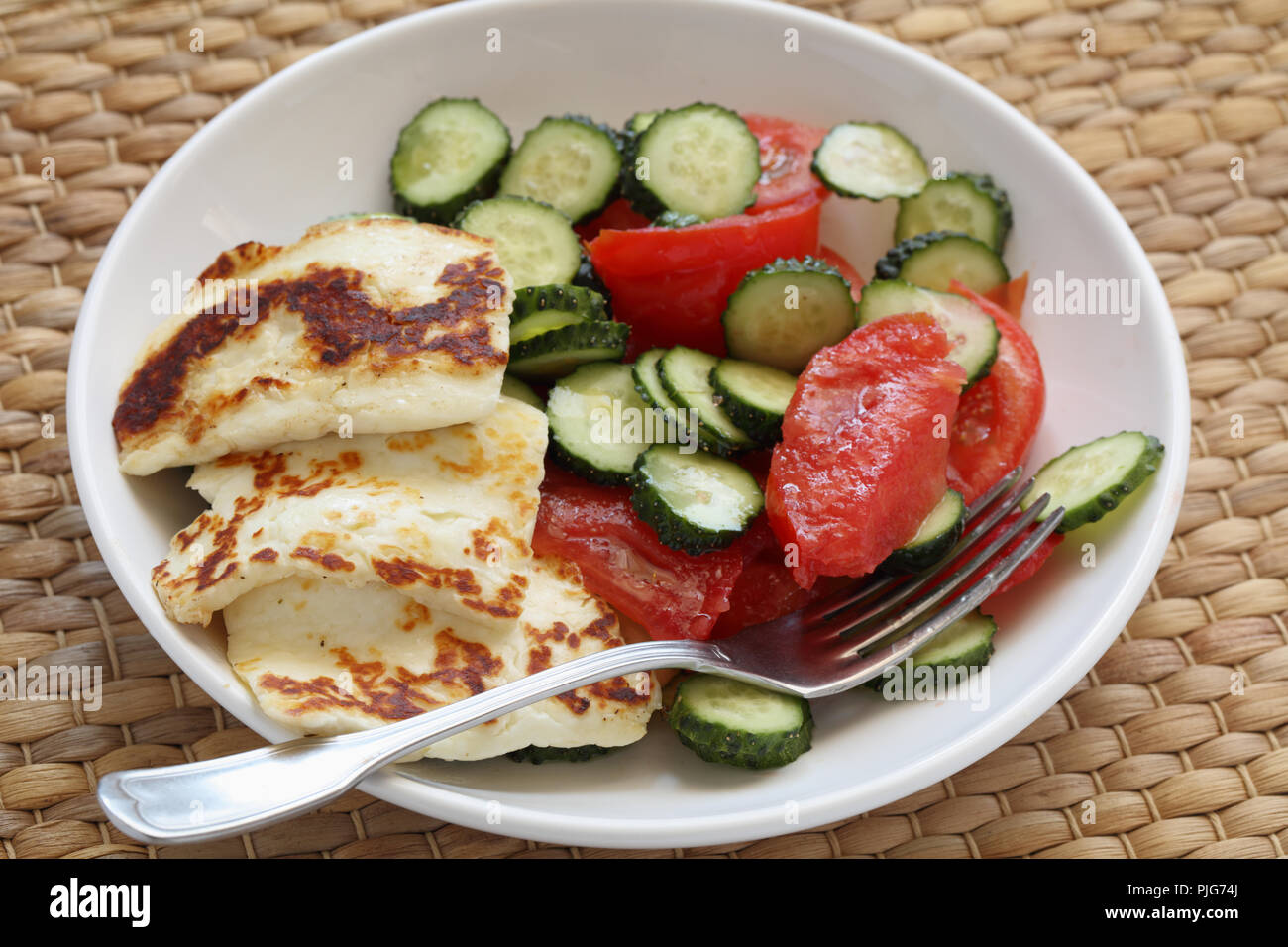 Arrosto di formaggio halloumi con pomodoro e insalata di cetrioli closeup Foto Stock
