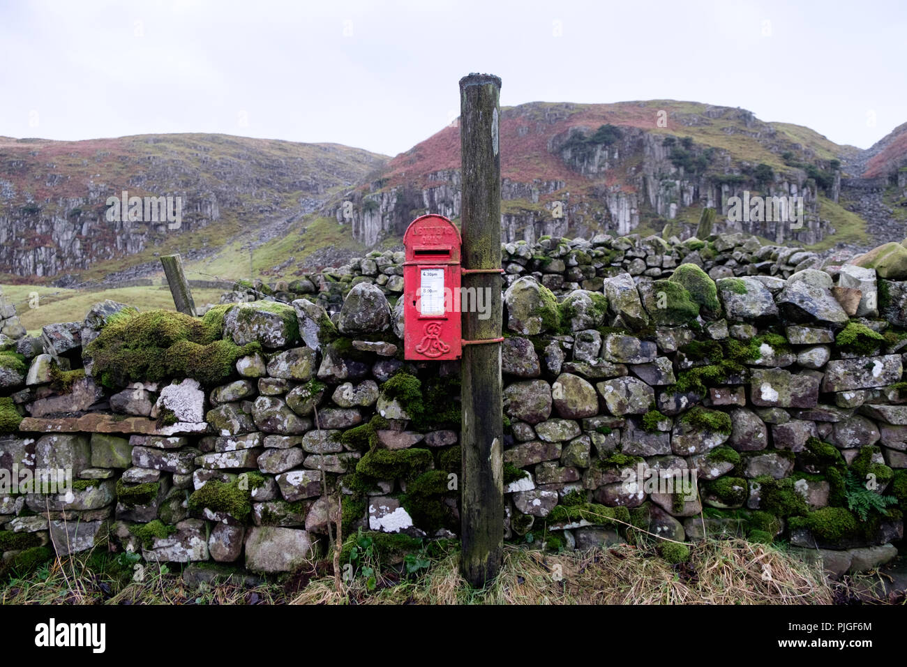 Un rosso brillante Edwardian post box con Edward VII royal cypher su una corsia rurale nella parte superiore Teesdale, County Durham, Inghilterra. Foto Stock