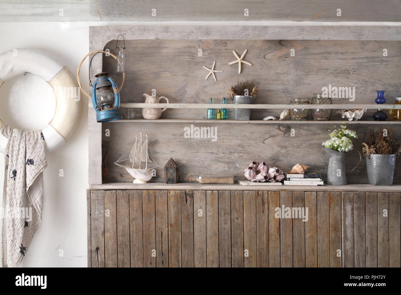 Il vintage parete in legno è un ripiano e decorate con un sacco di roba in stile marina Foto Stock