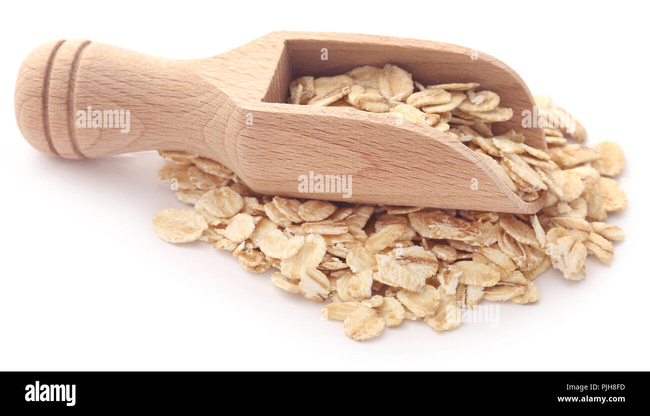 Avene intere in un cucchiaio di legno su bianco Foto Stock