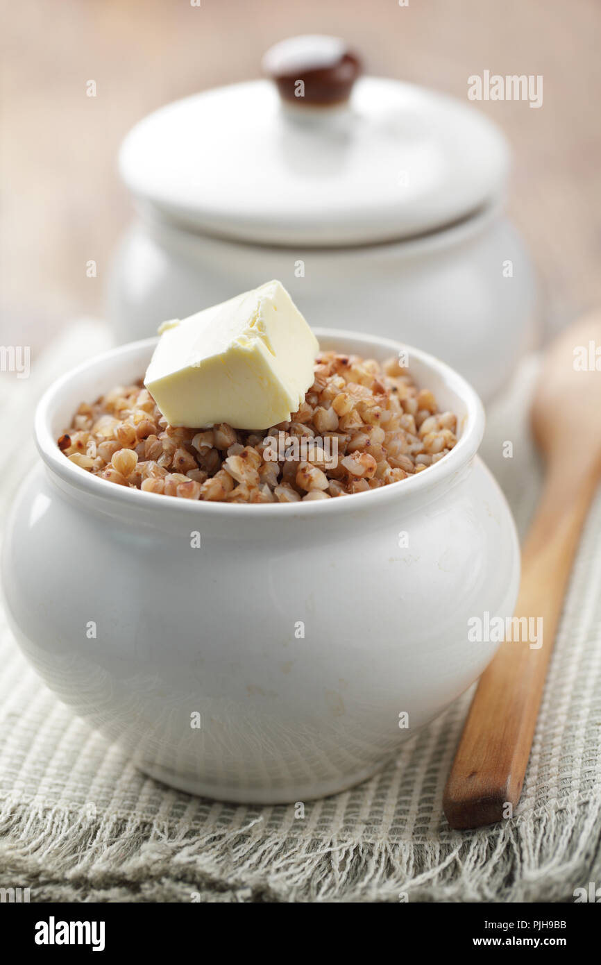 Il grano saraceno cereale nella pentola con il cubo di burro closeup Foto Stock