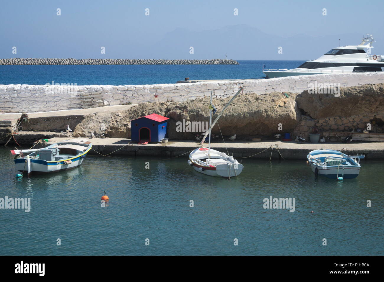 La Grecia, l'isola di Kasos. Tre piccole barche ormeggiate nel porto Foto Stock