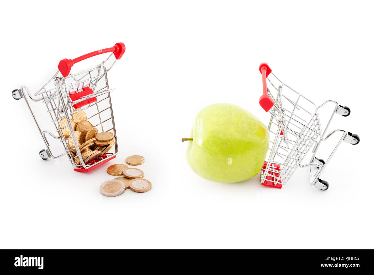 I carrelli della spesa con le monete in euro in caduta da esso su sfondo bianco e verde mela. Vendita, abbondanza, raccolto, supermercato shopping, vendita e cash back Foto Stock