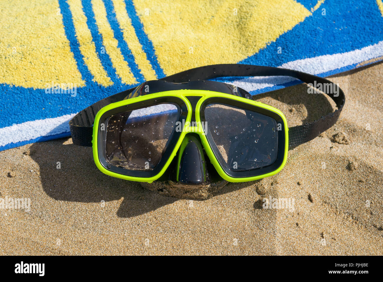 Maschera subacquea e un asciugamano sulla spiaggia Foto Stock