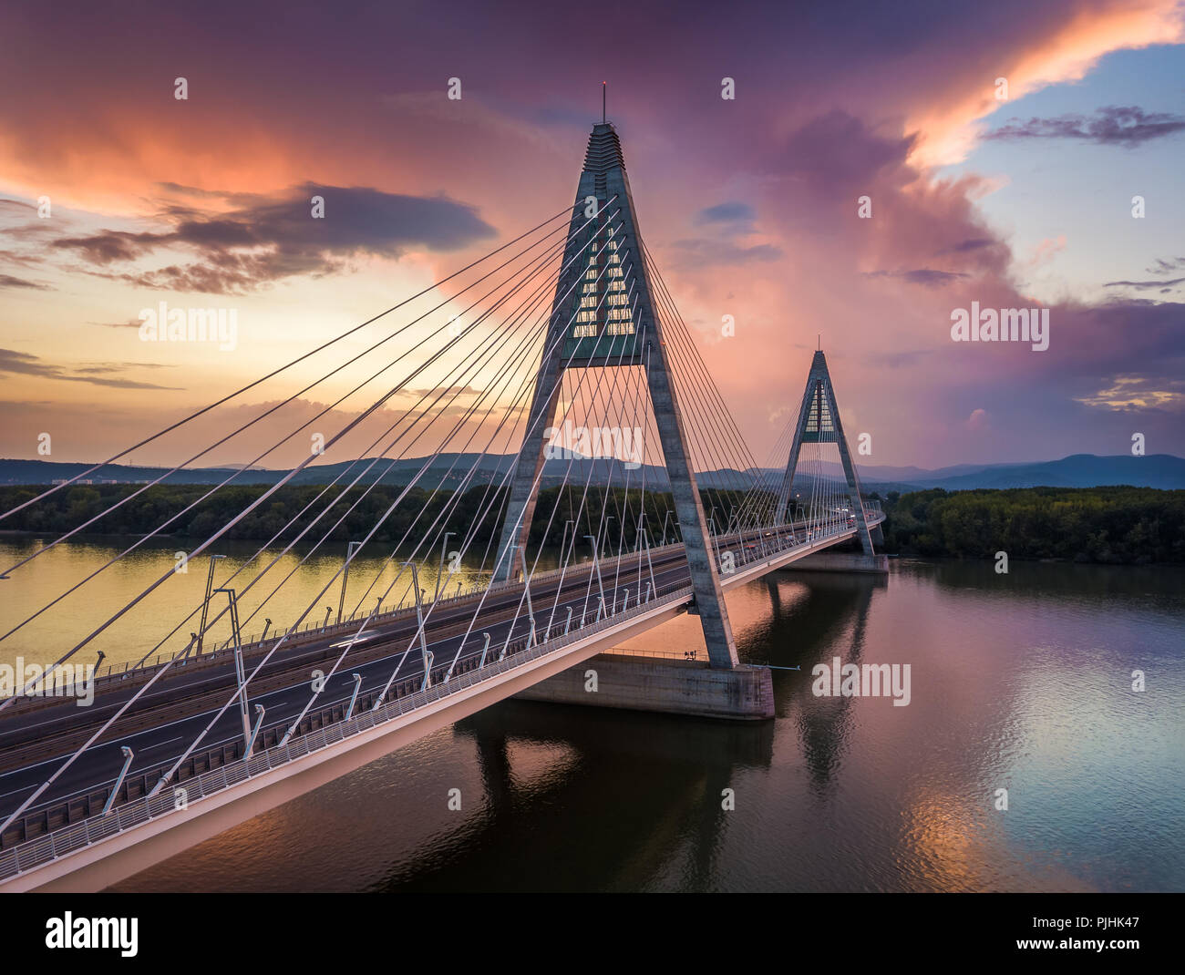 Budapest, Ungheria - Ponte Megyeri oltre il Fiume Danubio al tramonto con belle nuvole drammatico e cielo Foto Stock