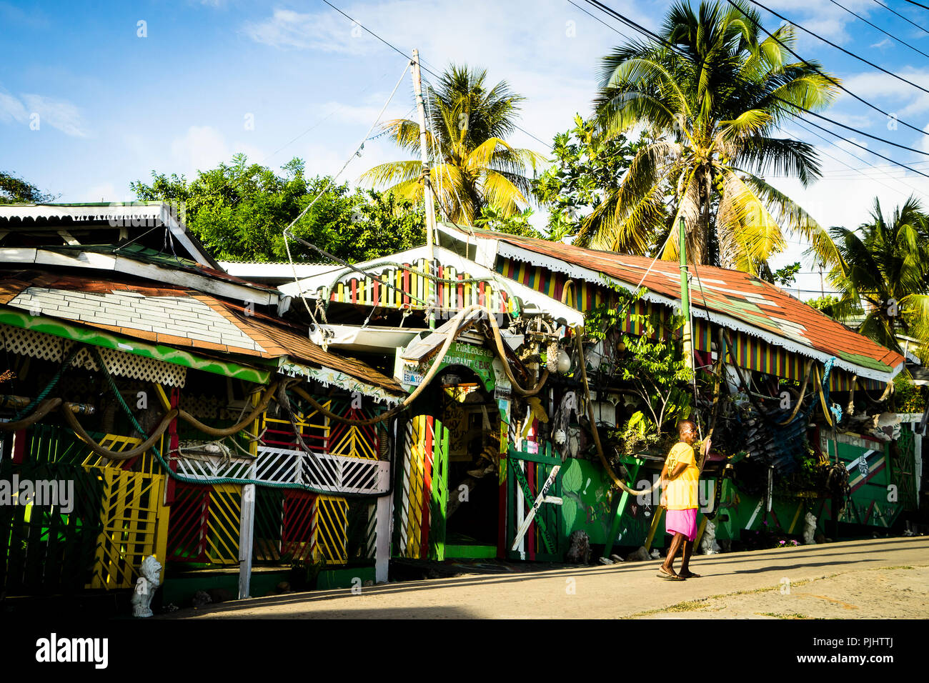 Una donna di fronte a un ristorante rasta, Soluzione Salina Bay, Mayreau, di Saint Vincent e Grenadine, West Indies Foto Stock