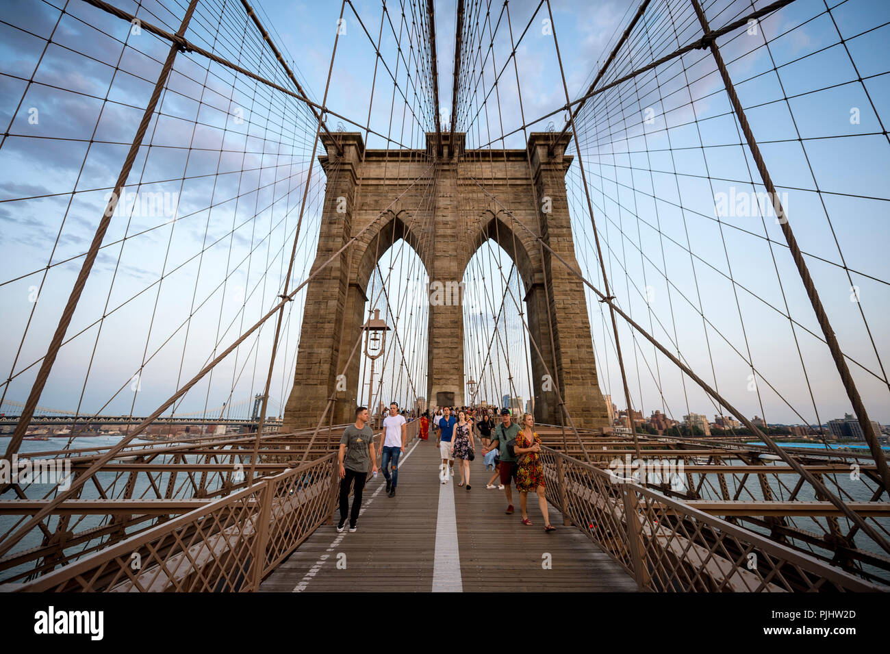 NEW YORK - Agosto 26, 2017: i turisti e la gente del posto la lotta per lo spazio sulla affollata strada pedonale che conduce attraverso il Ponte di Brooklyn al tramonto. Foto Stock