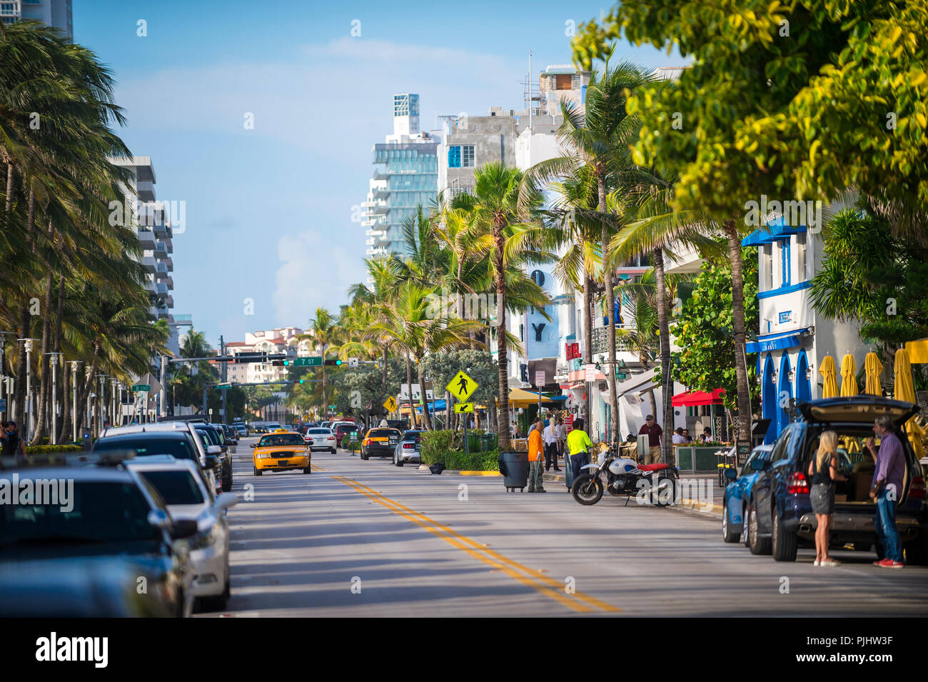 MIAMI, Stati Uniti d'America - circa luglio, 2018: Early Morning visualizza in basso a Ocean Drive foderato con palme e hotel art deco di South Beach. Foto Stock