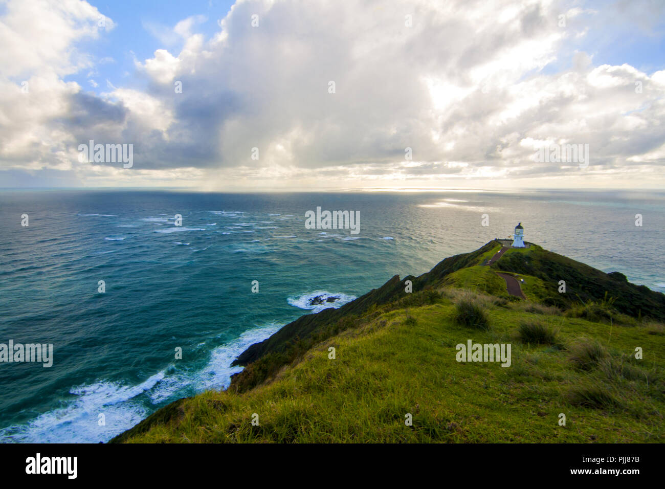 Bellissimo Oceano pacifico paesaggio con faro sulla cima della scogliera di picco, Cape Reinga Light house, Northland, Nuova Zelanda, seasascape landmark Foto Stock
