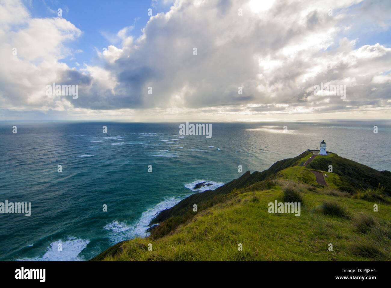 Incredibile vista panoramica del paesaggio marino con il faro sulla sommità della collina, Oceano Pacifico meridionale, Cape Reinga Lighthouse bella illuminazione sun Foto Stock