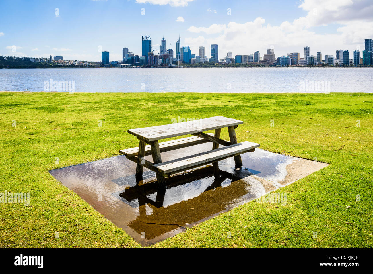 In legno Tavolo picnic in una grande pozza di acqua dal fiume Swan nel Sir James Mitchell Park, South Perth, Western Australia Foto Stock