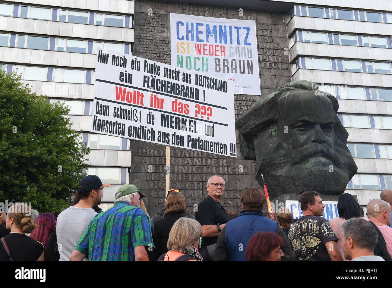 Chemnitz, Germania. 07Th Sep, 2018. Dimostrazione della destra populista alliance Pro Chemnitz: dimostranti tenere un poster con la scritta: "Solo una scintilla può girare la Germania in una zona incendio! È che cosa volete??? Quindi Merkel e la sua consorte sarà infine buttato fuori del Parlamento". Credito: Hendrik Schmidt/dpa/Alamy Live News Foto Stock