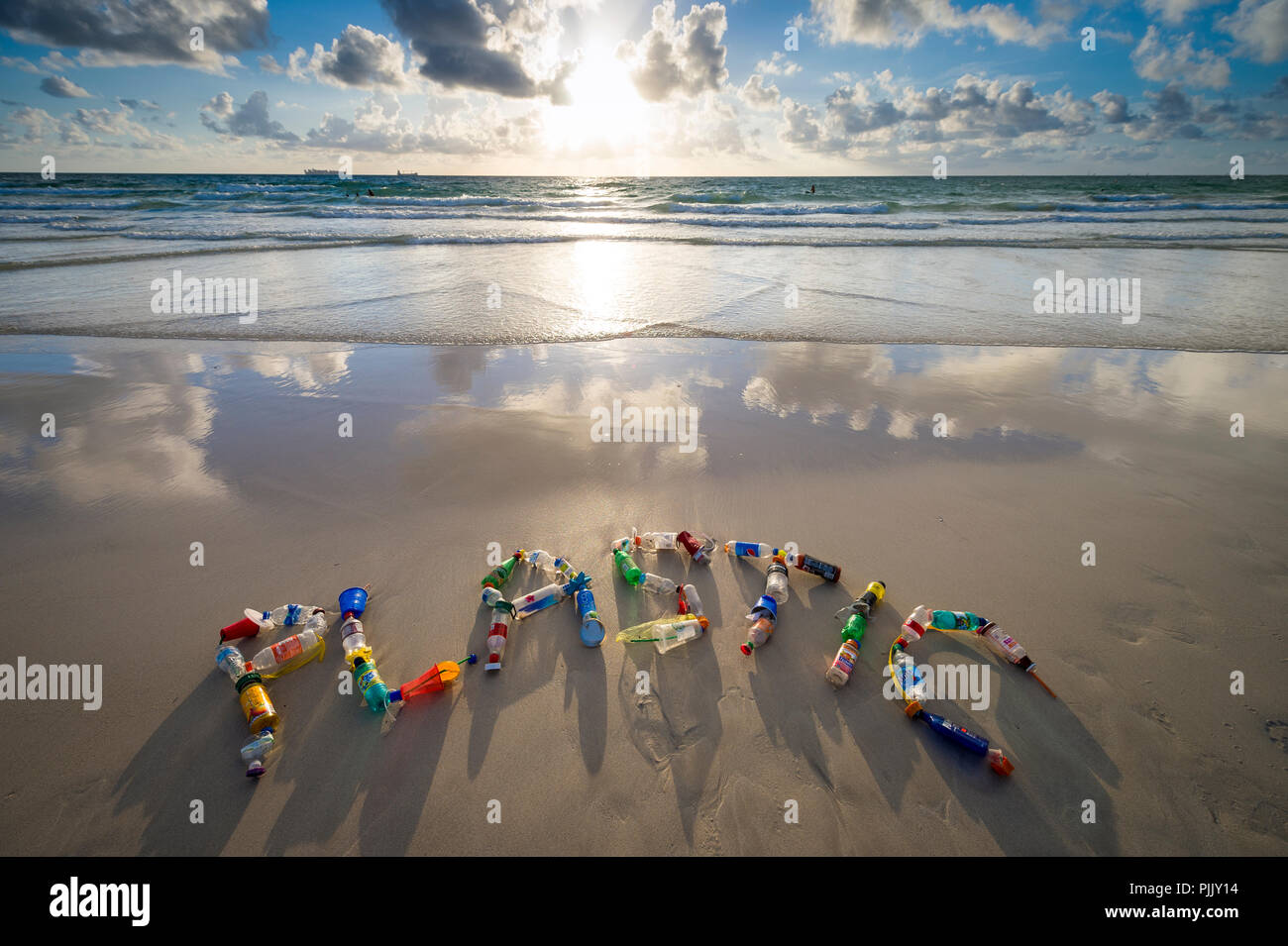 MIAMI - circa giugno, 2018: Plastica enunciato nella sabbia utilizzando garbage collection su Miami beach come promemoria per le persone a ridurre, riutilizzare e riciclare Foto Stock