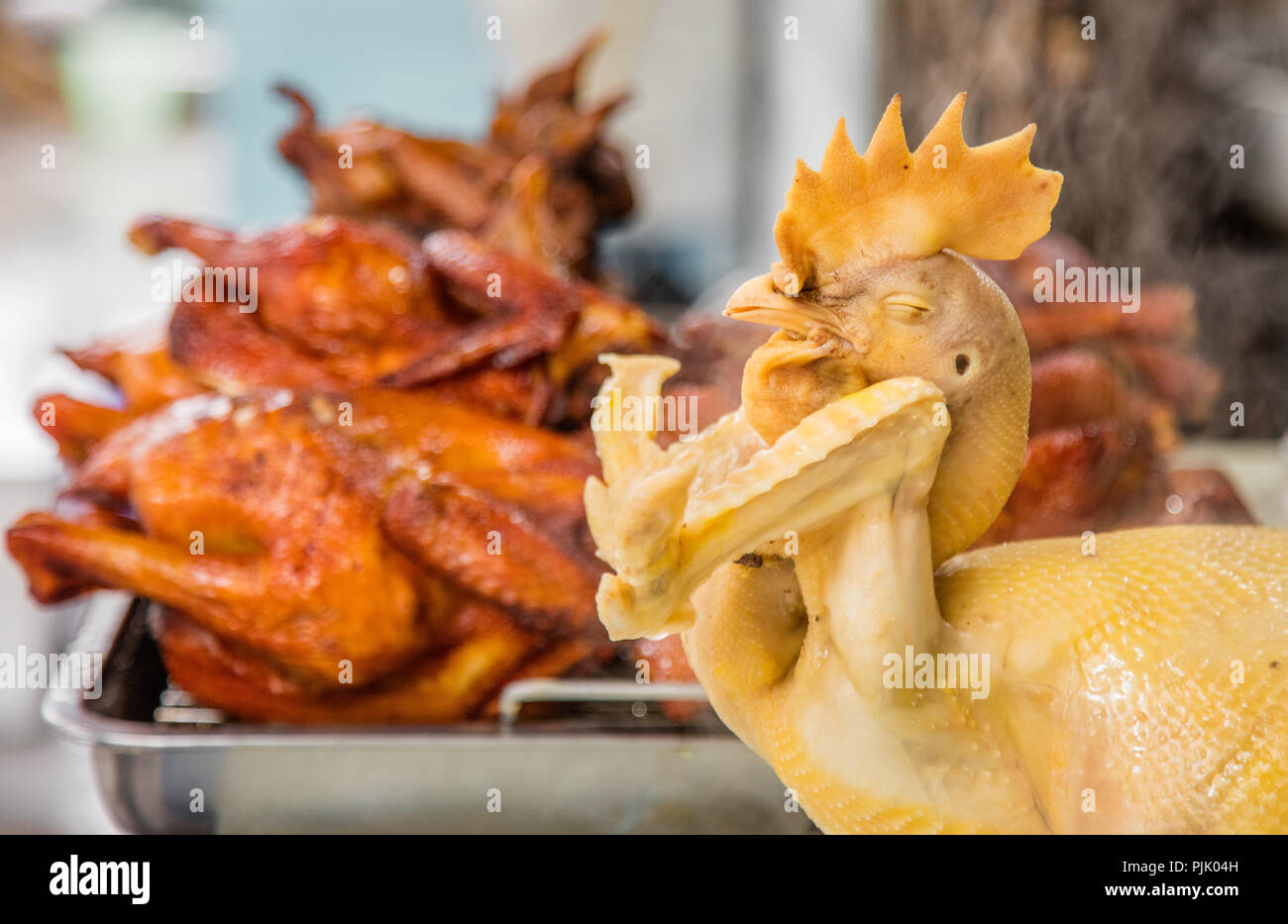 Arrosto di pollo intero venduto per le strade del mercato mattutino di Hanoi, Vietnam Foto Stock