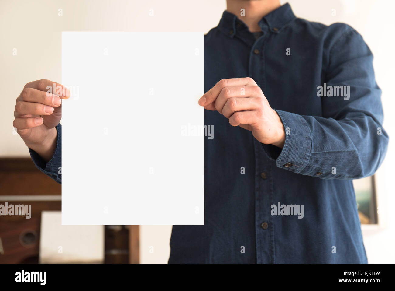 Un foglio di carta bianco con spazio libero detenute da una persona Foto Stock