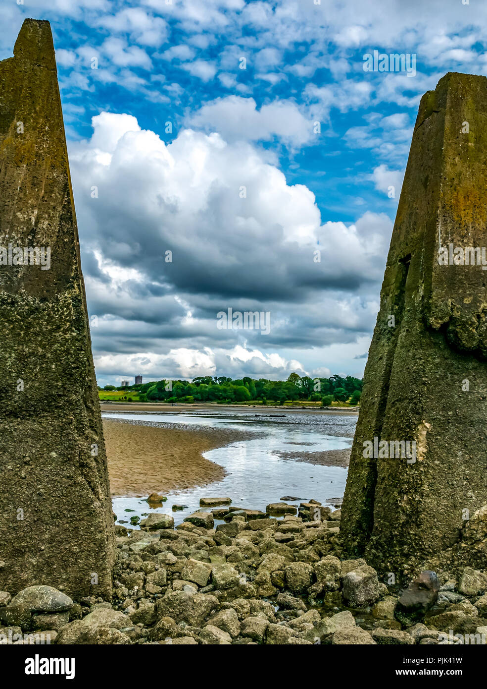 Vista della spiaggia di bassa marea attraverso anti piramide di spedizione piloni in cemento, Cramond causeway, Edimburgo, Scozia, Regno Unito Foto Stock
