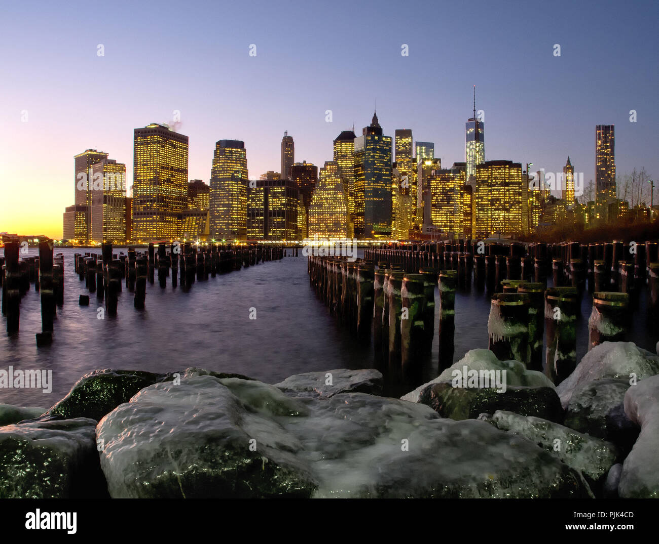 Skyline di Manhattan, New York City, Stati Uniti d'America, ghiacciate pietre e l'East River in primo piano Foto Stock