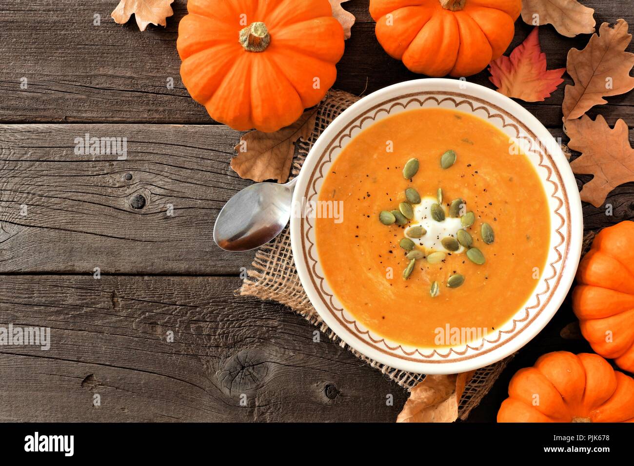 In autunno la zuppa di zucca, overhead rustico di scena sul fondo in legno Foto Stock