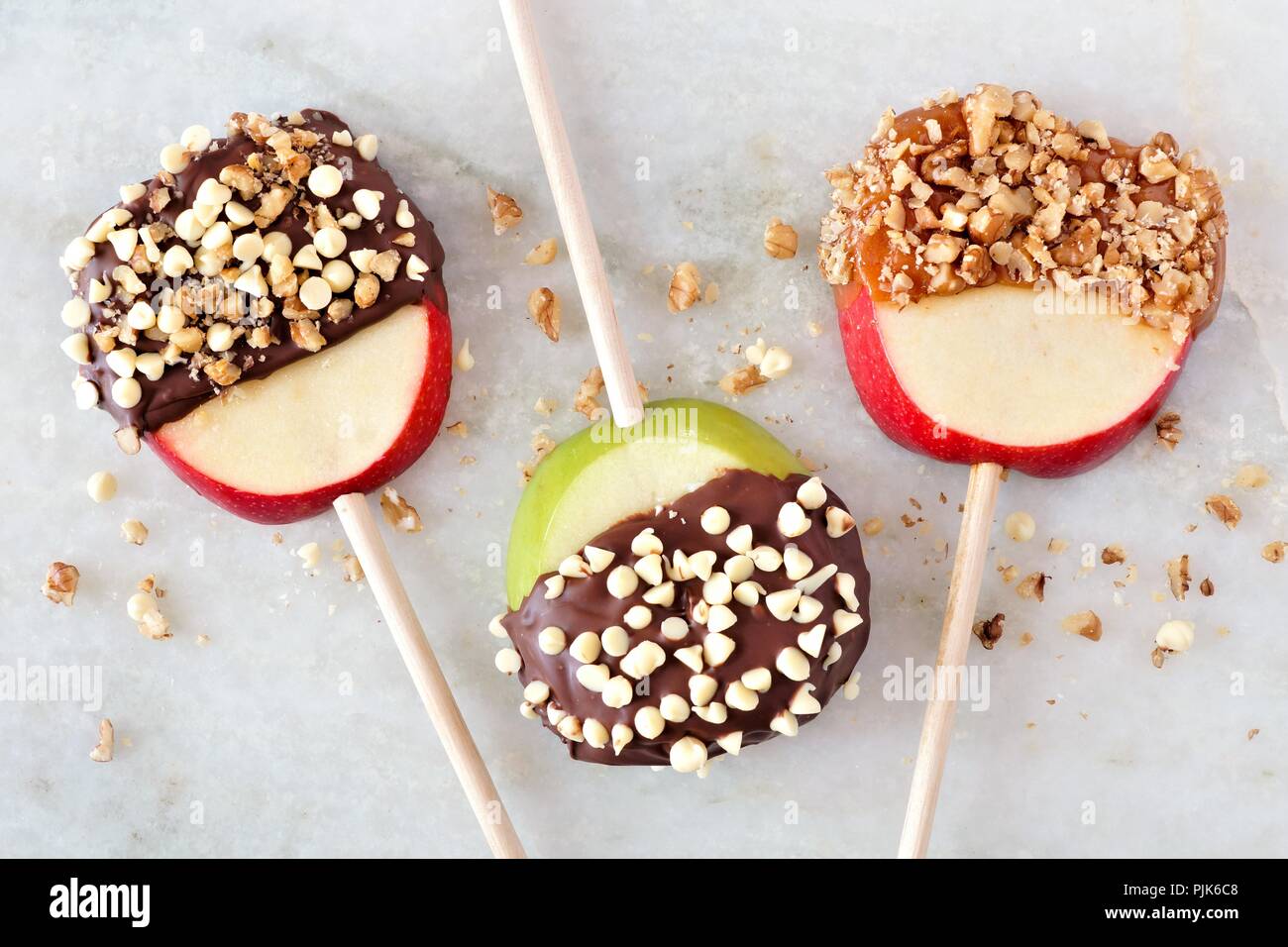 Tre autunno apple lecca-lecca immerso con cioccolato e caramello, vista aerea su marmo Foto Stock