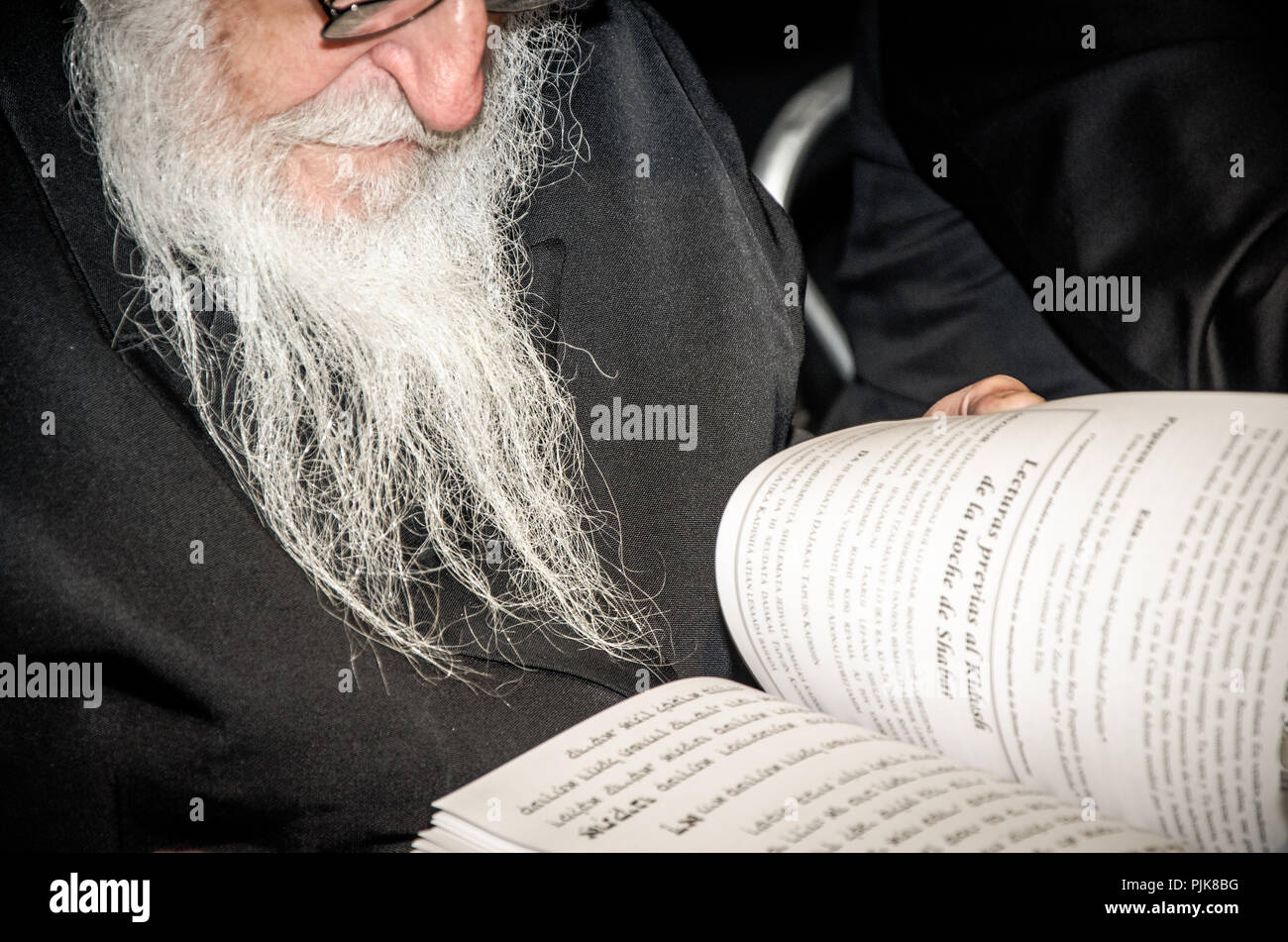 Senior uomo libro di lettura alla scrivania con occhiali in primo piano Foto Stock