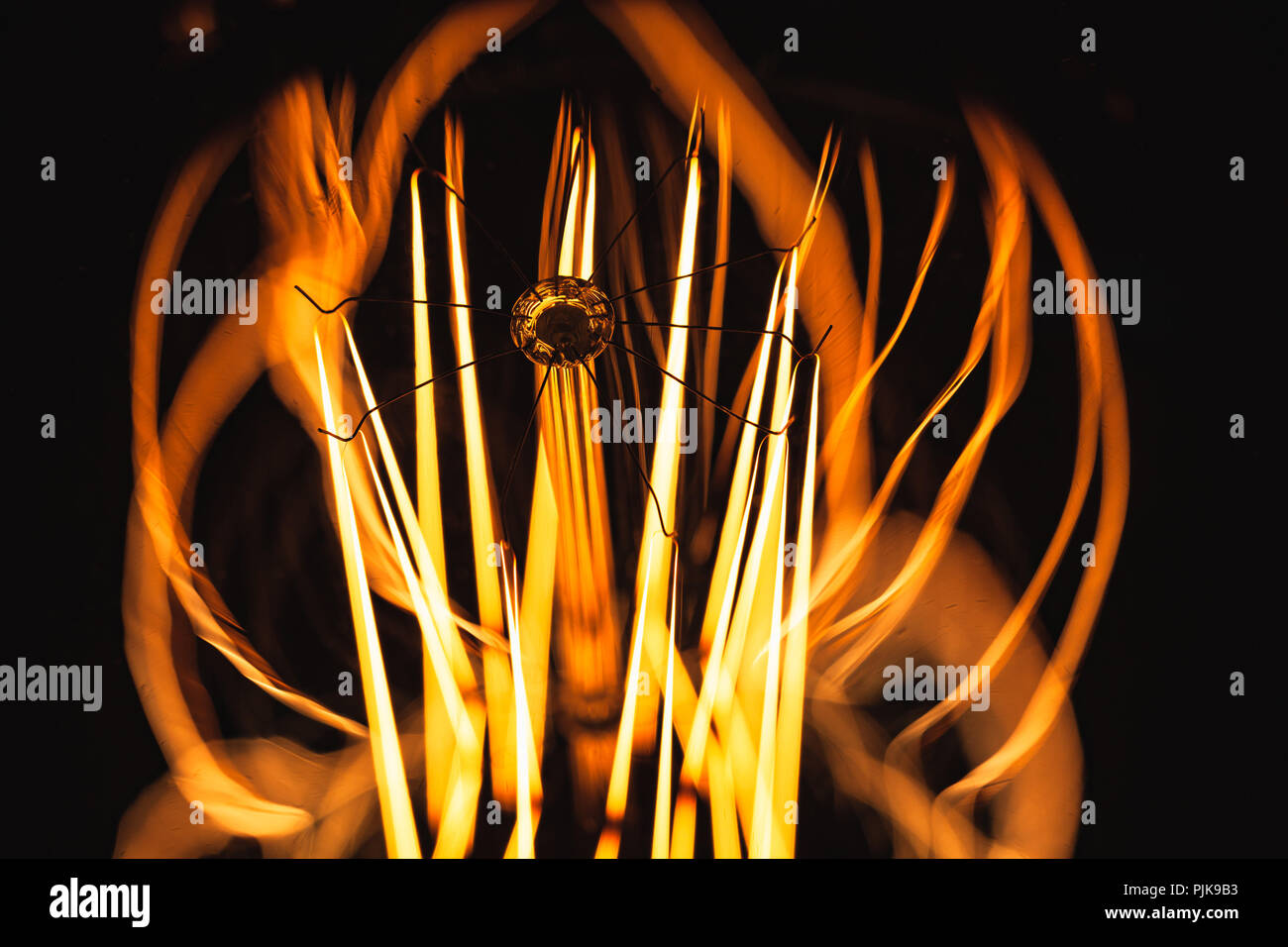 Lampada di tungsteno incandescente su sfondo scuro, Fotografia macro con messa a fuoco selettiva e DOF poco profondo Foto Stock