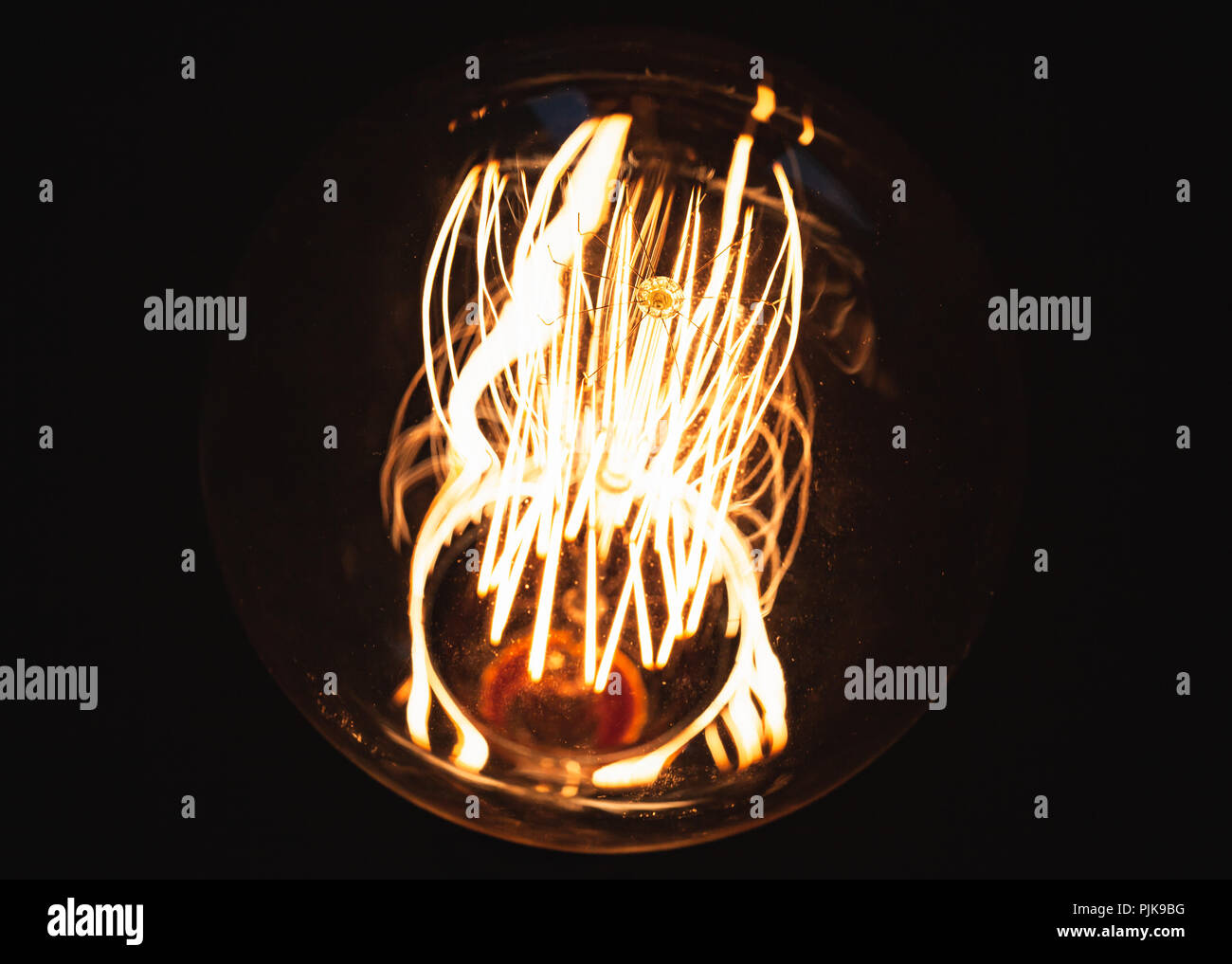 Retrò grande lampada di tungsteno incandescente su sfondo scuro, close-up foto con messa a fuoco selettiva e DOF poco profondo Foto Stock