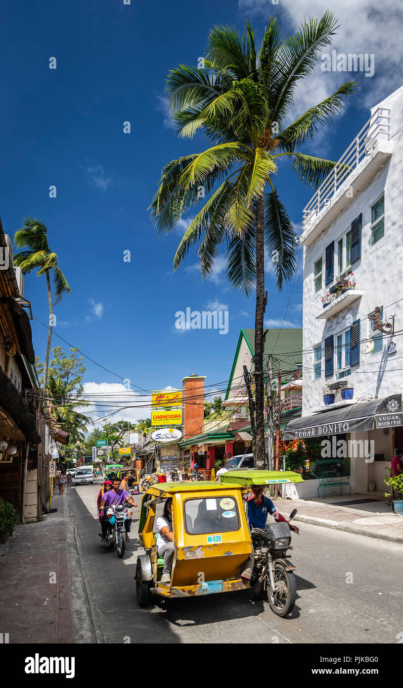 Un tuk tuk trike taxi il trasporto locale sulla strada principale nel centro di Isola Boracay Filippine Foto Stock