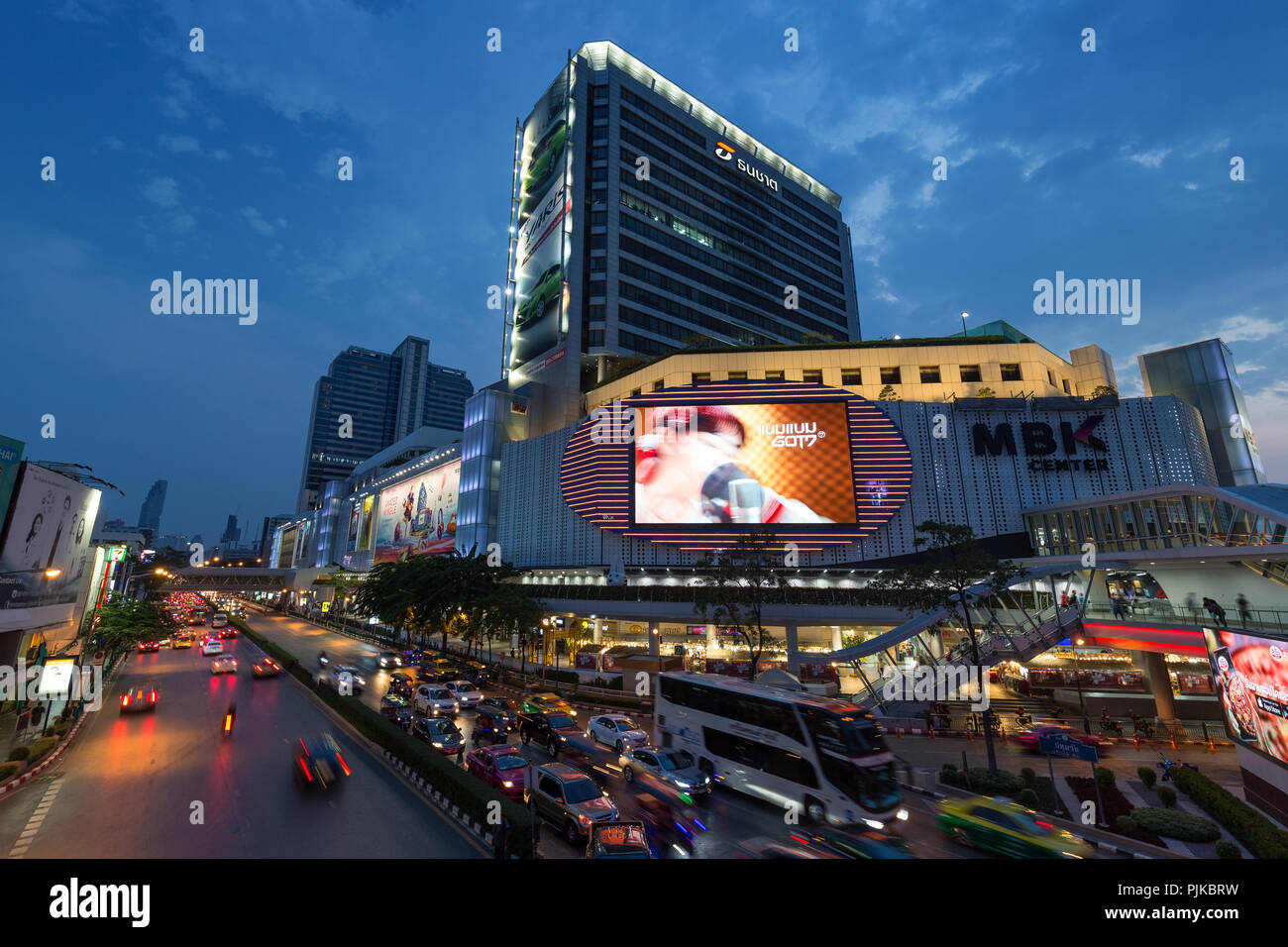 Vista panoramica del traffico su occupato Phayathai Road e MBK Centre shopping mall e altri edifici nel centro cittadino di Bangkok, Thailandia, al tramonto. Foto Stock