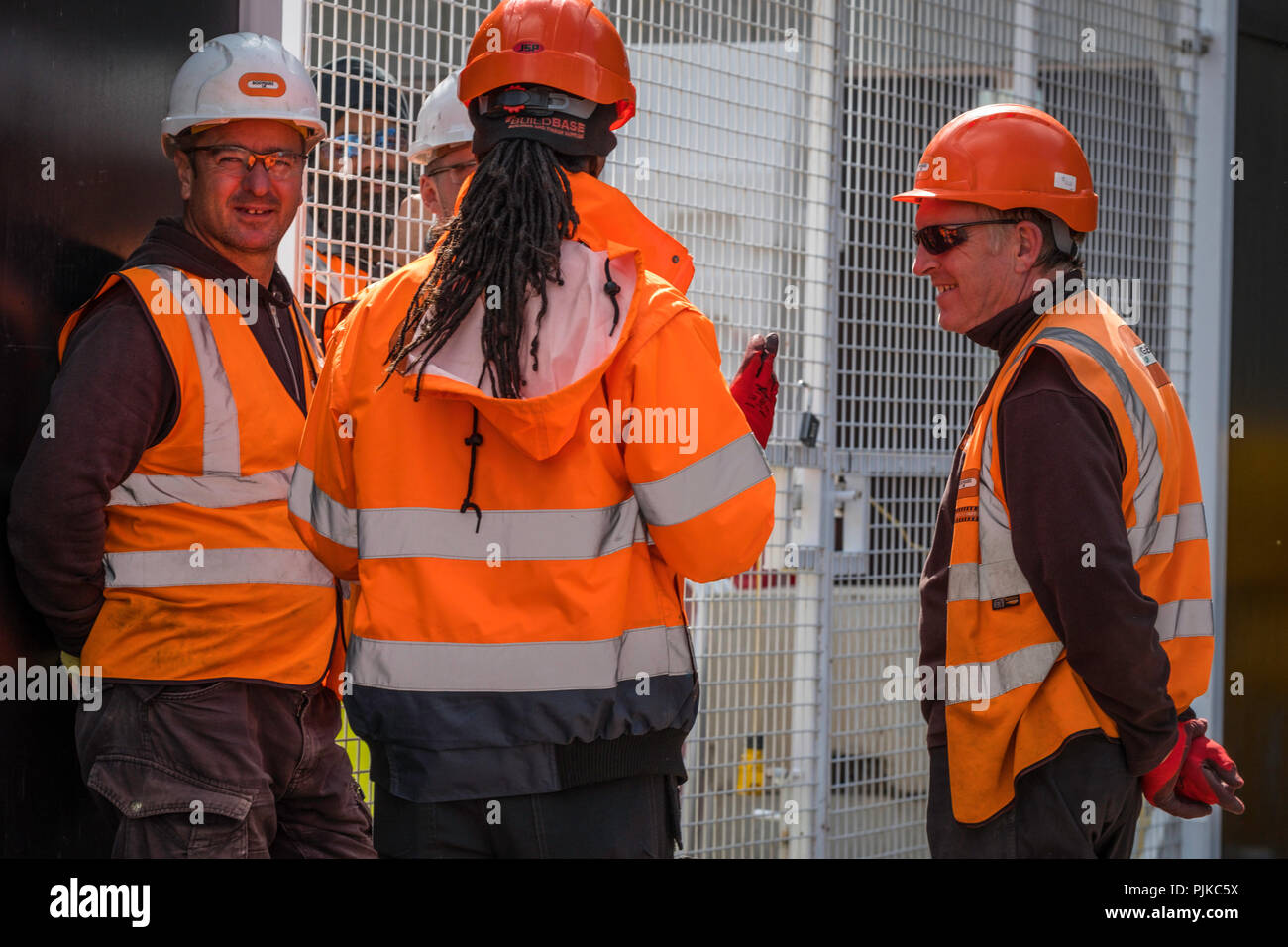 Lavoratori edili di indossare abbigliamento protettivo in discussione. Foto Stock