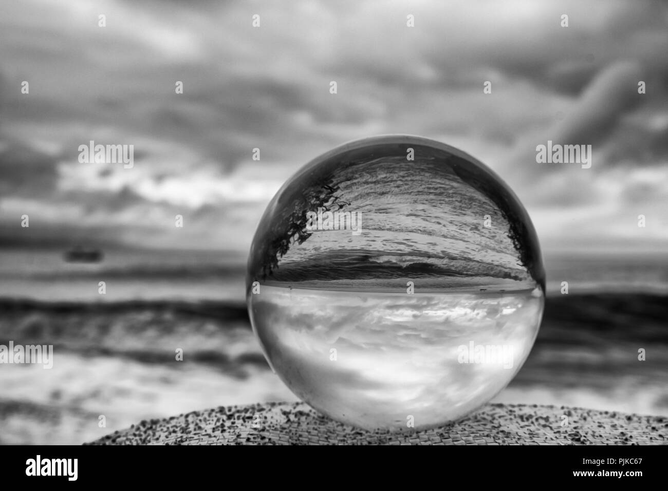 Cielo tempestoso e mari in bianco e nero attraverso la sfera di vetro Foto Stock