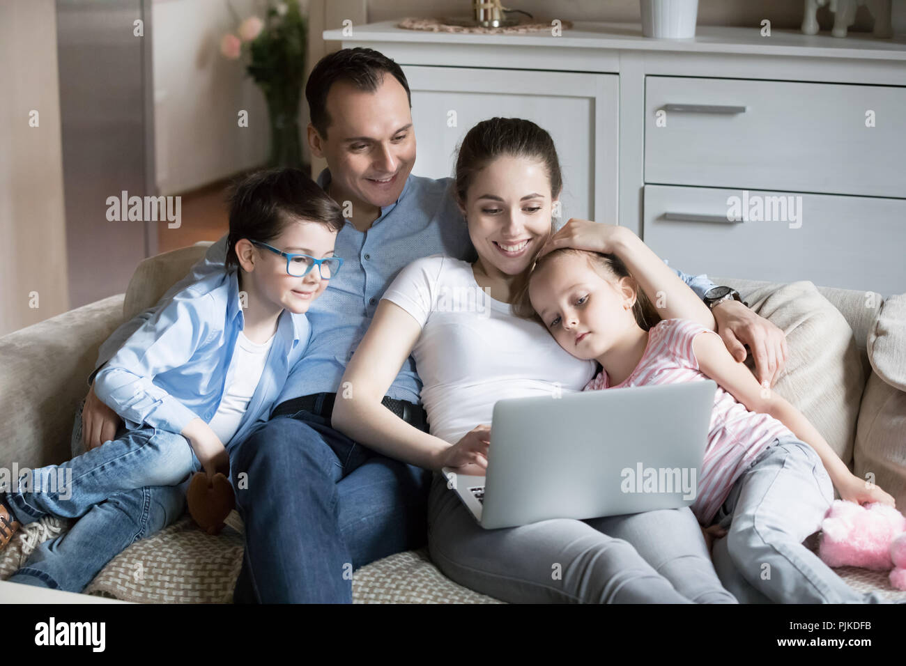 La famiglia felice con bambini guardare cartoni animati a togethe laptop Foto Stock