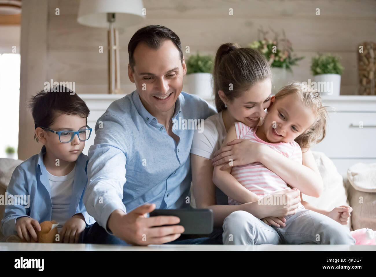 Padre sorridente rendendo selfie della famiglia felice di quattro Foto Stock