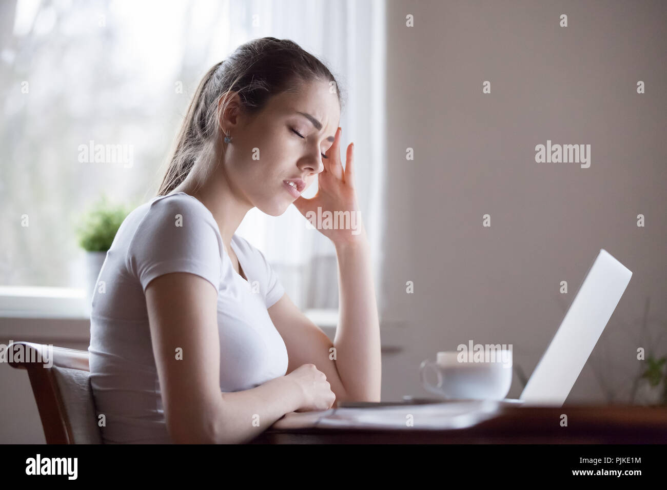 Stanco di sesso femminile affetti da mal di testa distratti forma di lavoro portatile Foto Stock