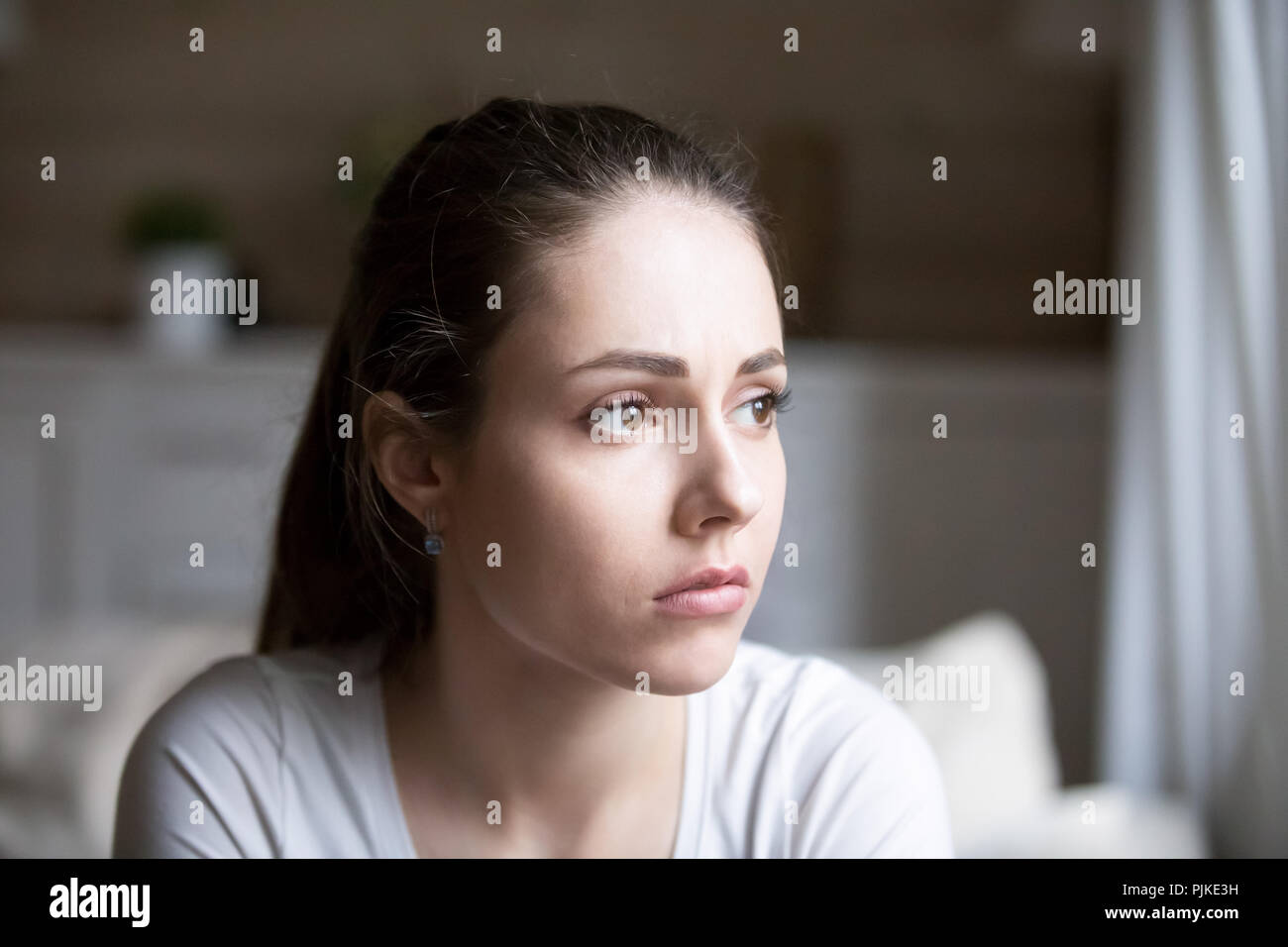 Triste donna che guarda lontano pensando a problemi personali Foto Stock