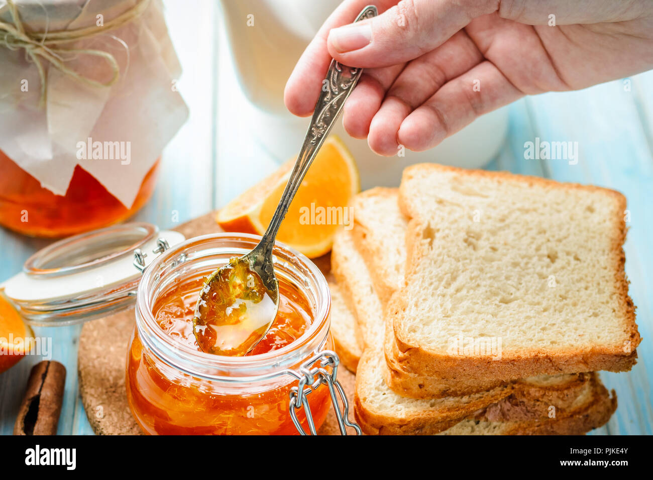 Donna di strisci mano brinda con fatti in casa orange jam Foto Stock
