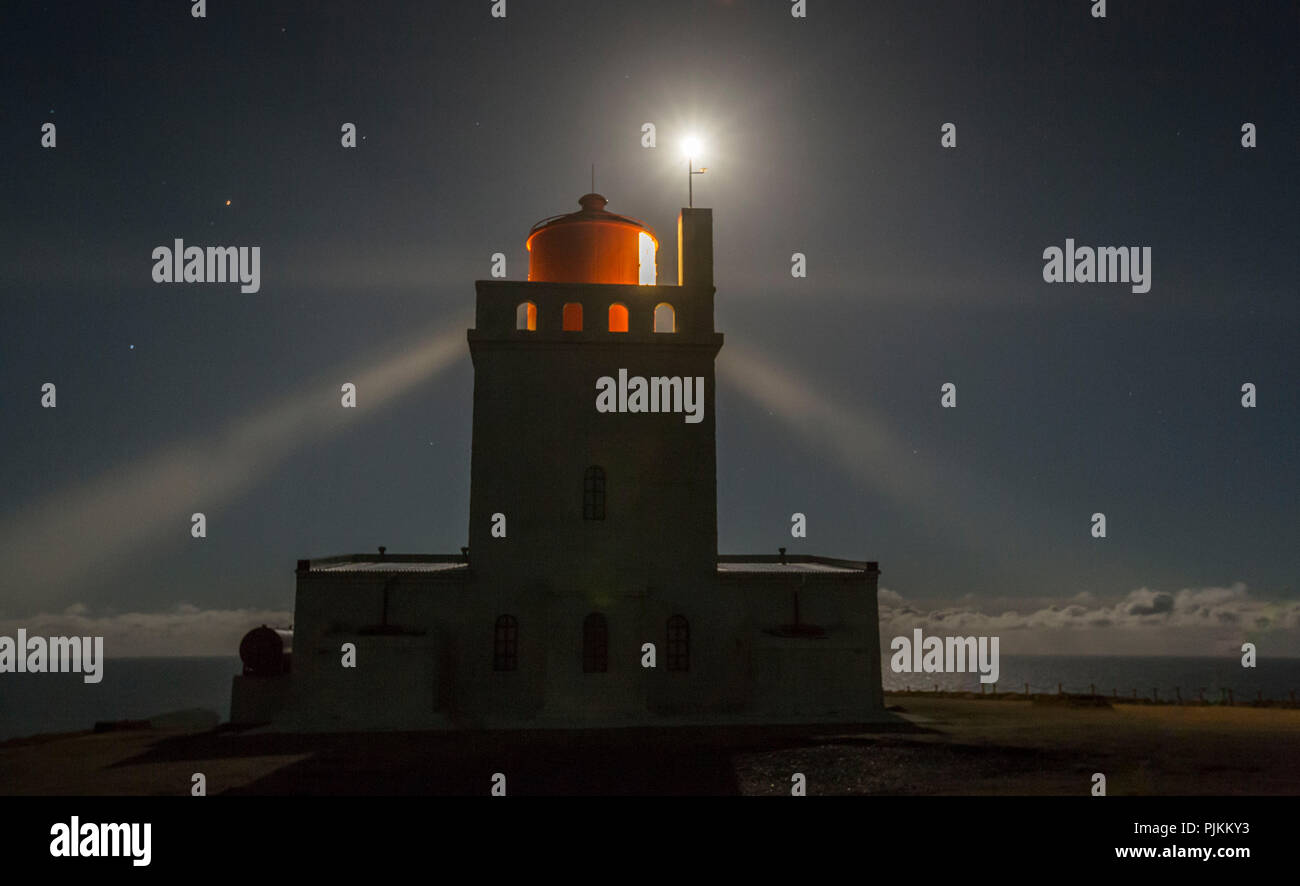 L'Islanda, il faro, a VIK, raggi di luce, cielo stellato, notte, Cape Dyrhólaey, la luna sul mare Foto Stock