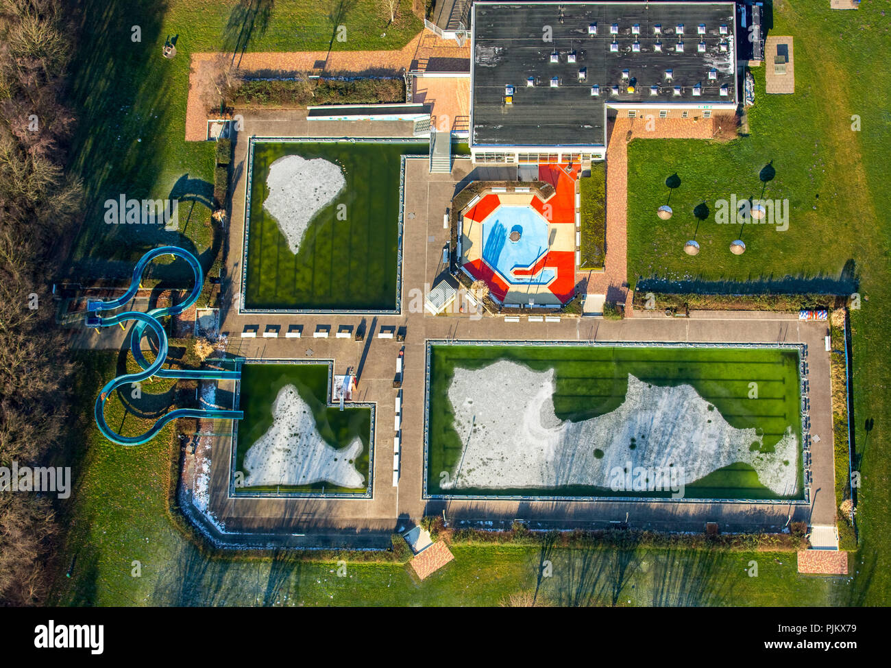 Piscina esterna a sud in inverno, piscina esterna Berge con verde acqua e ghiaccio in piscina, Hamm, la zona della Ruhr, Nord Reno-Westfalia, Germania Foto Stock