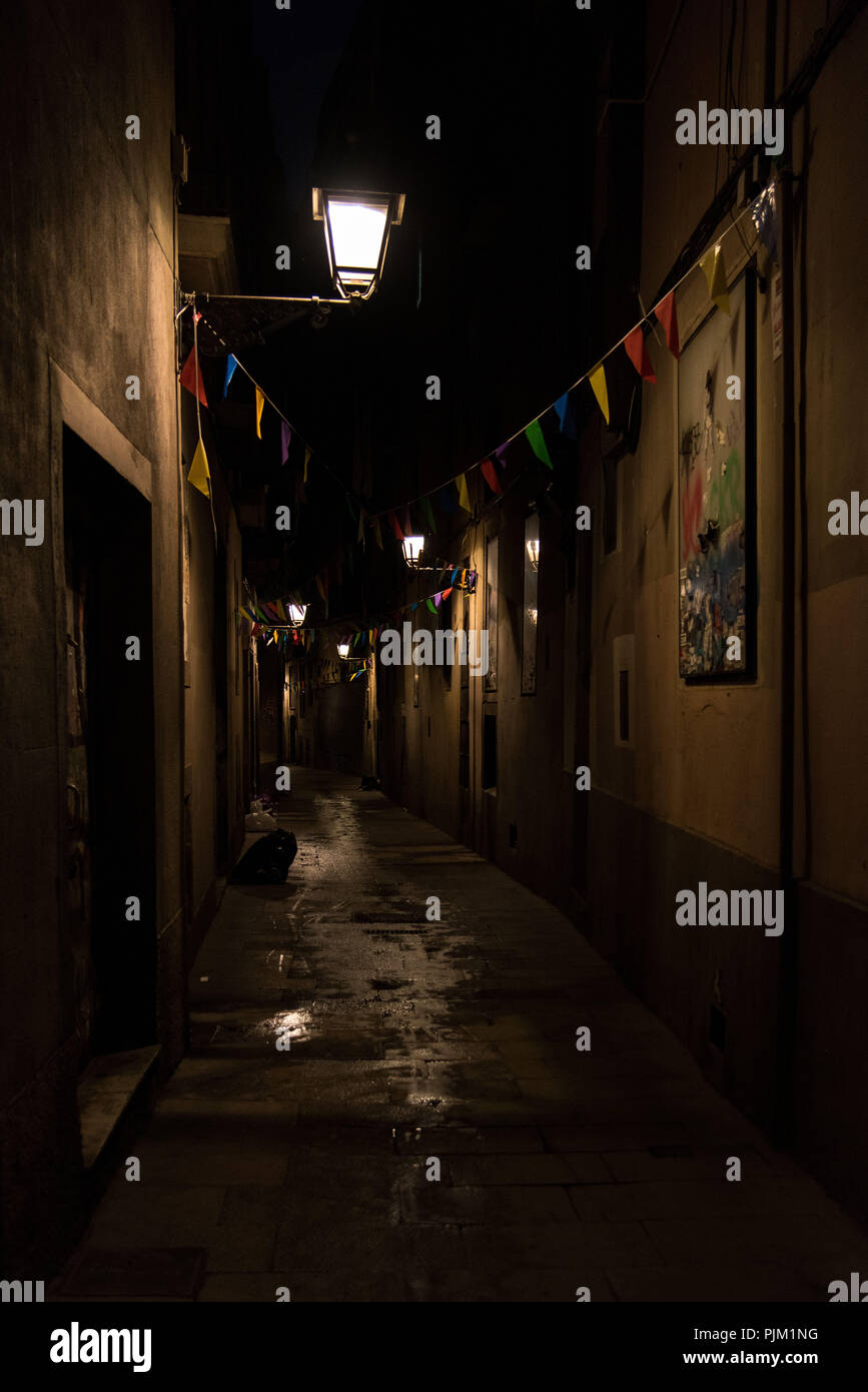 Barcellona in serata, un vicolo nel Barri Gòtic con bandiere colorate e lanterne Foto Stock