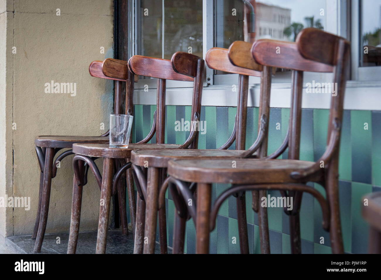 Impressioni da strade di Barcellona, ??4 sedie di legno nella parte anteriore di un street cafe con un bicchiere vuoto Foto Stock