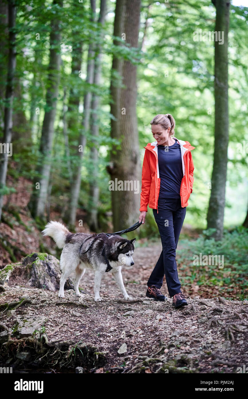 Donna con cane, la camminata nella foresta Foto Stock