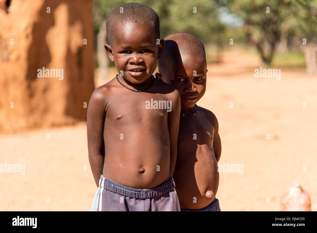 Due ragazzi Himba cercando timido e curioso nella fotocamera Foto Stock