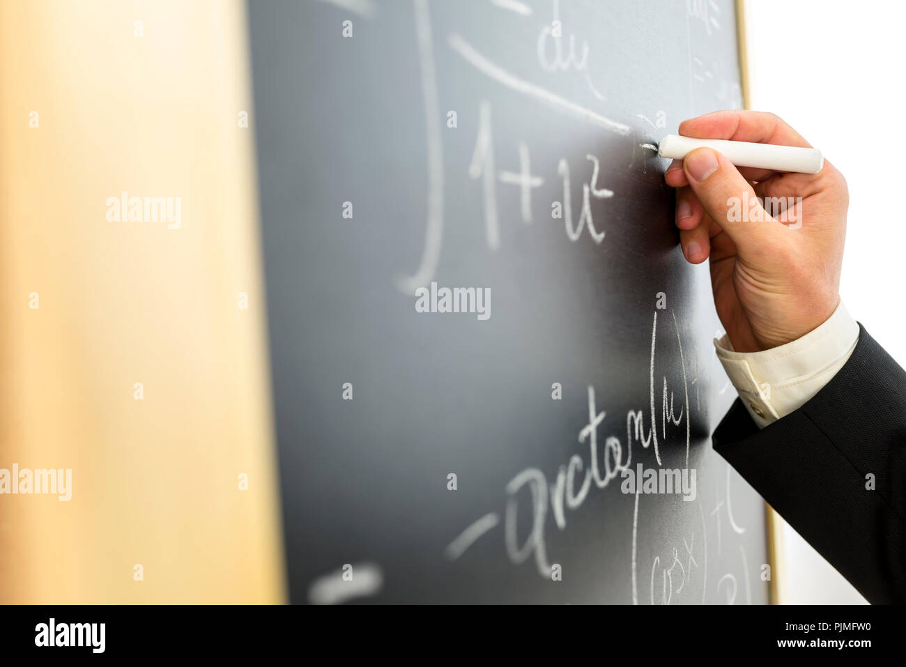 Vista dettagliata del collegio professore di matematica scrivere complicati equazione sulla lavagna nera. Foto Stock