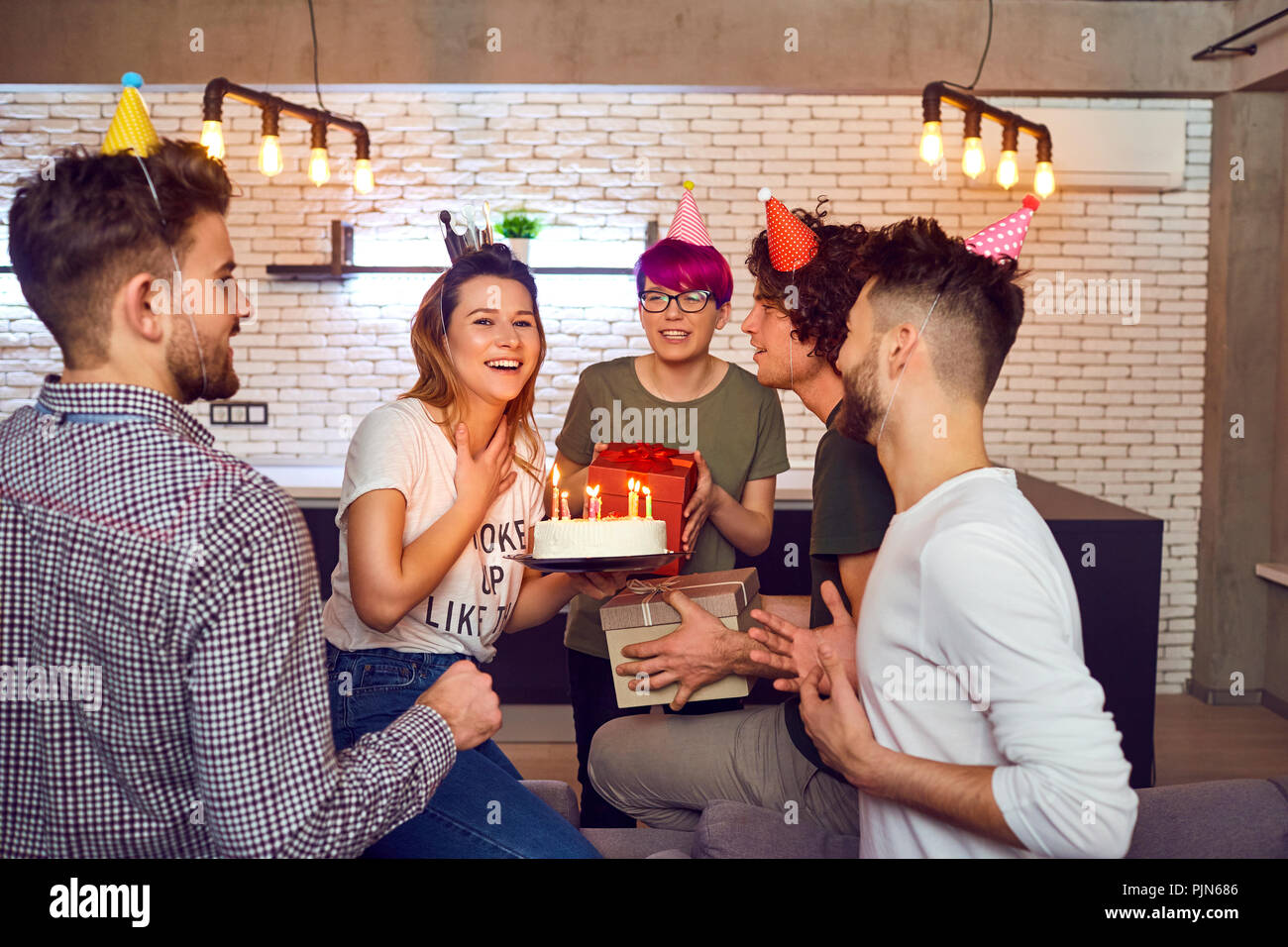 Amici con torta con candele festeggia il compleanno. Foto Stock