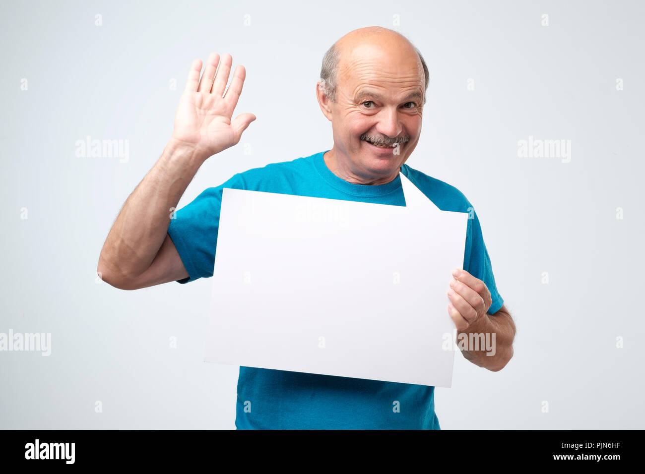 Senior ispanico uomo con i baffi tiene il cartello bianco in un studio sullo sfondo bianco Foto Stock