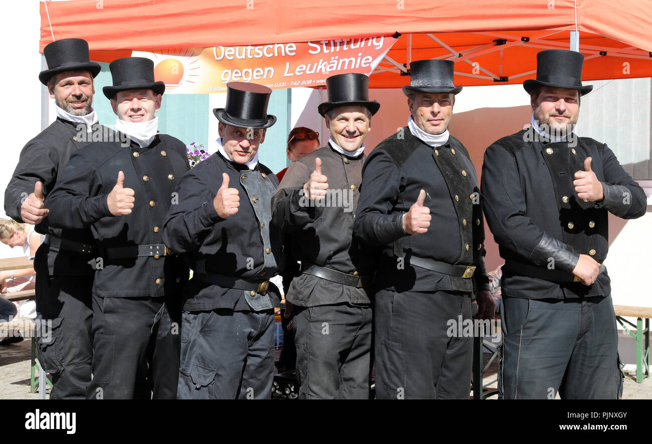 Ducherow, Germania. 08 Sep, 2018. Il camino spazzatrici (L-R) Mike Grueneberg, Dirk Sommer, Rene Kellermann, Ralf Schmidt, Uwe Grube e Olaf Stahl dal Kreisgruppe Ostvorpommern-Greifswald der Schornsteinfeger-Innung sono allo stand di informazione del 'Associazione Tedesca contro la leucemia' prima di fornire un campione di saliva. Con il loro aspetto in uniforme, vogliono portare fortuna nella ricerca di un idoneo di cellule staminali del sangue del donatore per un cittadino di Ducherow chi soffre di leucemia. Credito: Bernd Wüstneck/dpa/Alamy Live News Foto Stock